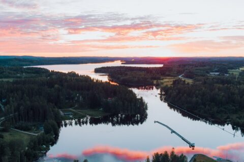 Ilmakuva kauniista auringonlaskusta Laukaassa järven yllä.