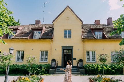 Person standing in front of an old beautiful house.
